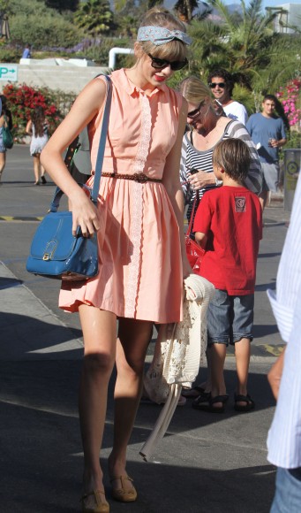 Taylor Swift in a peach shirt dress and blue bag