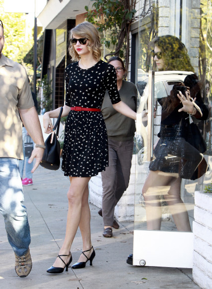 Black bird print dress with cross strap heels out shopping with Lorde